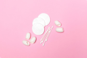 Cotton pads and cotton swabs on pink background