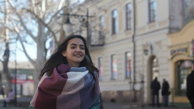 Active brunette girl with long hair going in a street in winter in slow motion 