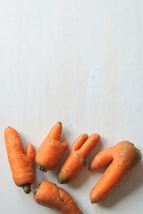 Imperfect carrots with ugly shapes. Copy space