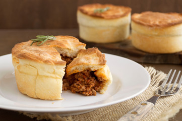 Australian meat pie on wooden table close-up with copy space, rustic style