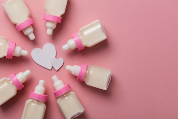 Baby bottle on a pastel pink background. New baby arrival