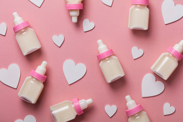 Baby bottle on a pastel pink background. New baby arrival