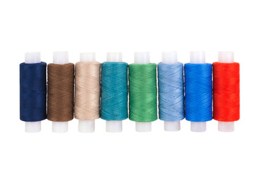 Multi-colored sewing reels stand in a row on a white background, isolated