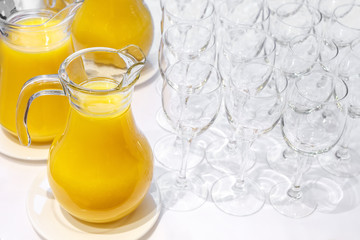 Pitchers of orange juice and a clean glass