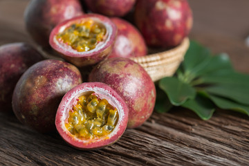 Half of  passion fruit and organic passionfruit on wood basket, wooden background.