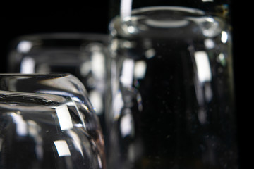Close up of three different empty shot glasses on black background.