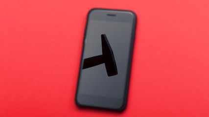 The hammer is reflected on the phone screen on a red background. Phone repair concept