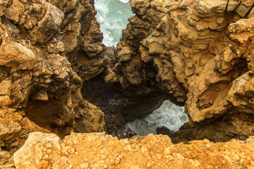 landscape of orange rocks and ocean waves Portugal, Sagres