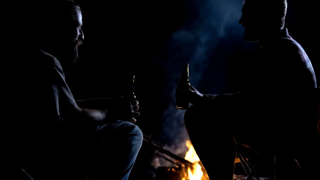 Friends Sitting Around Campfire, Drinking Beer And Chatting, Men Talks, Camping