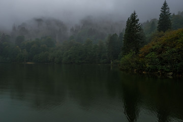 Misty hills over lake.