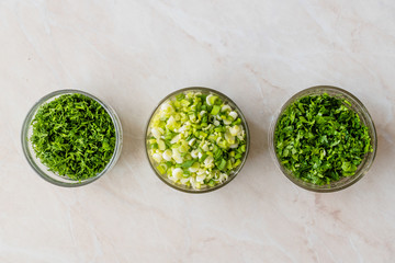 Chopped Chives, Parsley and Dill in Glass Bowls.