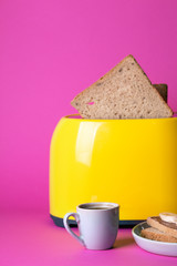 yellow toaster on a pink background