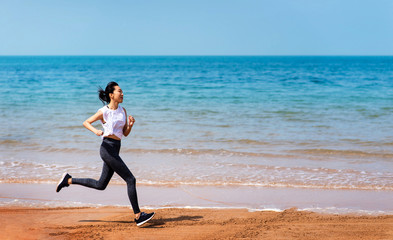 Woman running on the beach on a sunny day