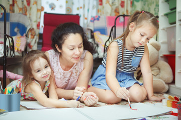 Mom and daughters painting pictures and lying on floor