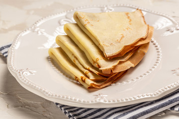 Crepes, thin pancakes on a white plate. white background. sweet breakfast. food recipe, copy text