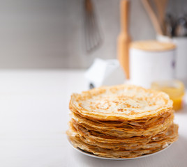A stack of thin russian pancakes on a white plate