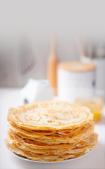 A stack of thin russian pancakes on a white plate