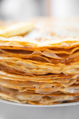 A stack of thin russian pancakes on a white plate