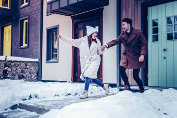 Couple feeling excited before winter walk and enjoying snow