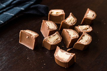 Tahini Filled Chocolate Pieces on Dark Wooden Surface / Tahin.