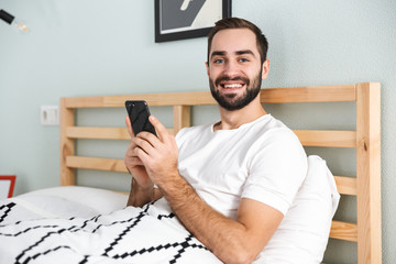 Handsome young man laying in bed