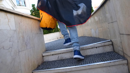 Kid with Trick or Treat bag running upstairs to neighbor house for candies