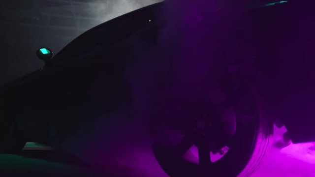 Silhouette of beautiful american muscle car on smoked dark background . Car lights on fog . 