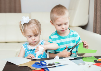 cute, smiling children, boy and girl, brother and sister 3-5 years old, scissors and cut out applications
