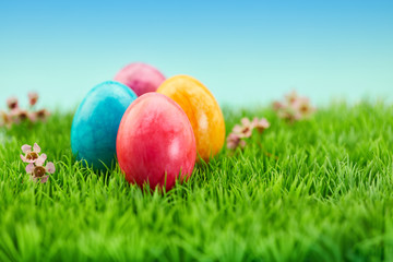 Bunte Eier auf Wiese zu Ostern als Hintergrund