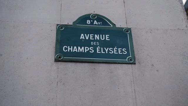 Classic street sign of Avenue Champs Elysees or Elysian Fields located on a house in Paris. France. Shot with parallax effect relative to houses in the background. Illustration of shopping and