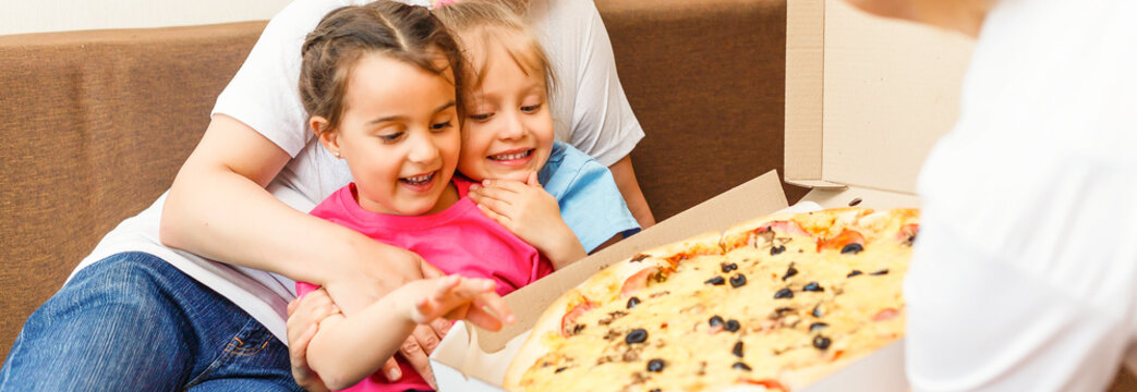 Happy Family Eating Pizza On The Wooden Table