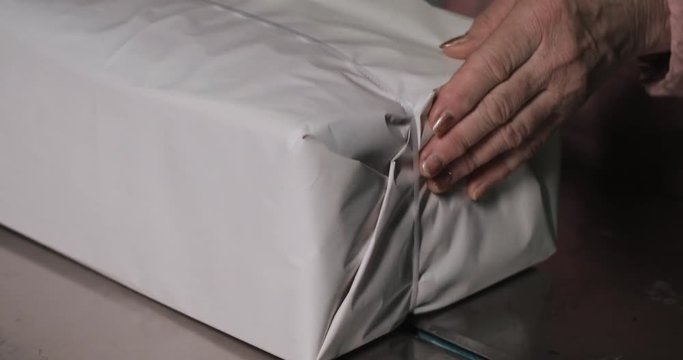 Packaging process of a sheaf of newspaper held by a woman on the old newspaper factory
