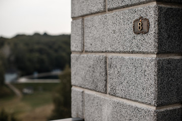 A big brick column with a metal plate with a number 8 on it.