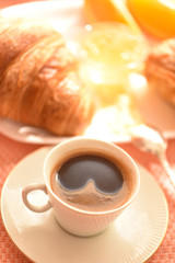 Delicious continental breakfast with fresh flaky croissants, assorted preserves, orange jam and coffee with milk, close up on the cup of coffee02