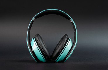Fototapeta na wymiar Beautiful audio over ear big headphones on dark background, front view, standing upright.