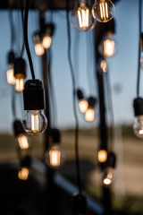 A lot of light bulbs hanging on a wires.