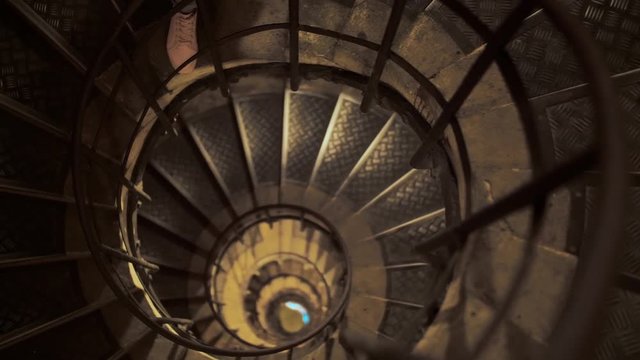 Panoramic shot of a high spiral staircase from above. Focus on the front of the stairs. The concept of an unknown future.