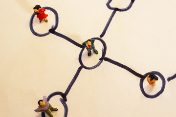 Business network scheme which contains miniature business people connected to each other. Networking concept.