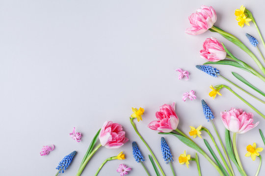International Women Day greeting card. Beautiful spring flowers on pastel table from above. Flat lay.