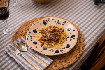 spaghetti bolognese served with wine
