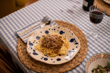 spaghetti bolognese served with wine