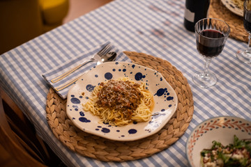 spaghetti bolognese served with wine