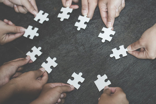 Business concept,  Group of business people assembling jigsaw puzzle and represent team support and help togethe