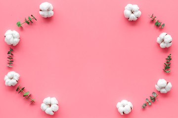 Flowers composition on pink desk with feucalyptus branches and cotton. Flat lay, top view, copy space