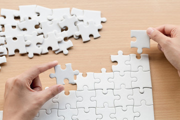 Business woman is trying to connect couple puzzle piece. Symbol of association and connection. Concept of business strategy