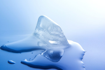 Melting ice cube. Close-up. Macro. White blue tone. Side view.