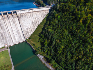 Aerial scenic view of a dam constructed on a beautiful valley in mountains. water storage reservoir. road with beautiful views for travel and holidays. lake Lzvorul Muntelui, Romania.