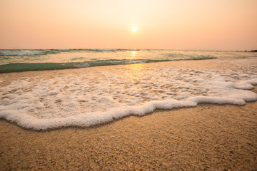 Wave of blue ocean on sandy beach,in sunset. summer background for travel and relaxation in holiday