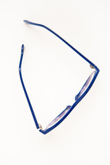 Glasses in the blue frame on a white ground, flat lay