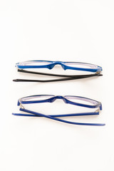 Glasses in the blue frame on a white ground, flat lay